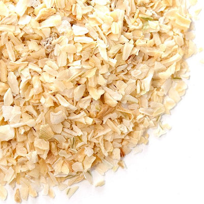 Close-up of freshly chopped onion on a cutting board, showcasing the crisp, white and translucent pieces with a hint of natural moisture, ready for culinary use.